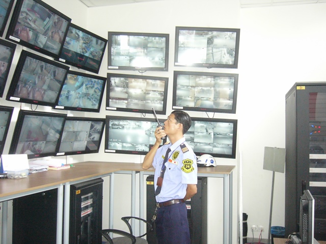Bảo vệ tòa nhà kiểm tra an ninh qua hệ thống màn hình camera